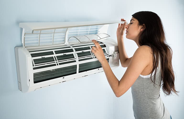 Woman Cleaning Air Conditioning Unit